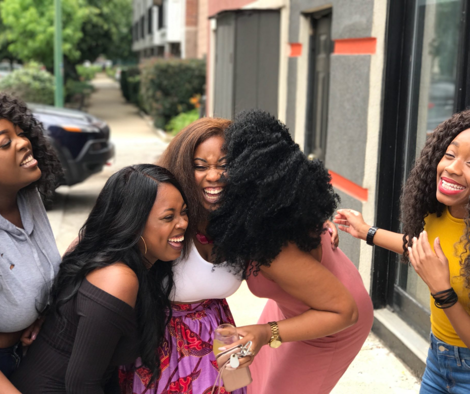 Five Black women smiling and laughing