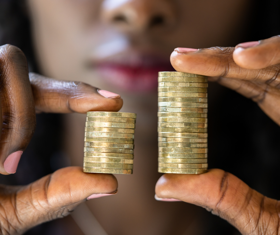 Black woman holding two stacks of differing coins