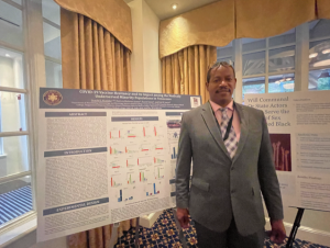 a man stands in front of a research poster