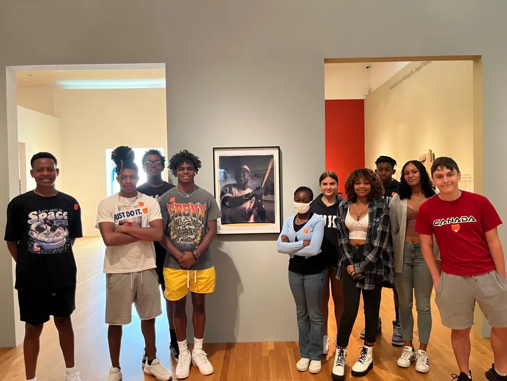 a group of Young Scholars standing in front of a framed image
