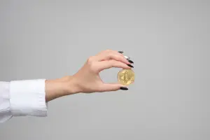 hand holding a gold coin