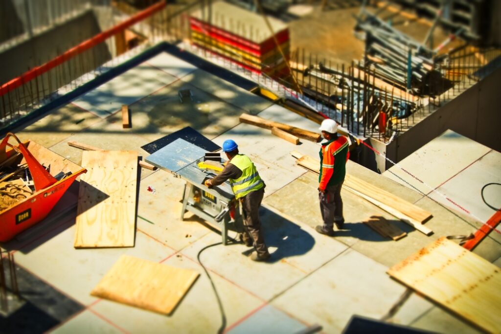 two construction workers near a saw