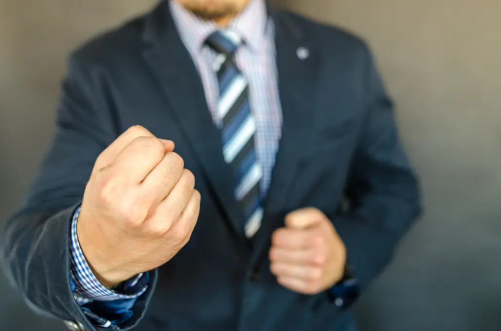 person in suit making fists