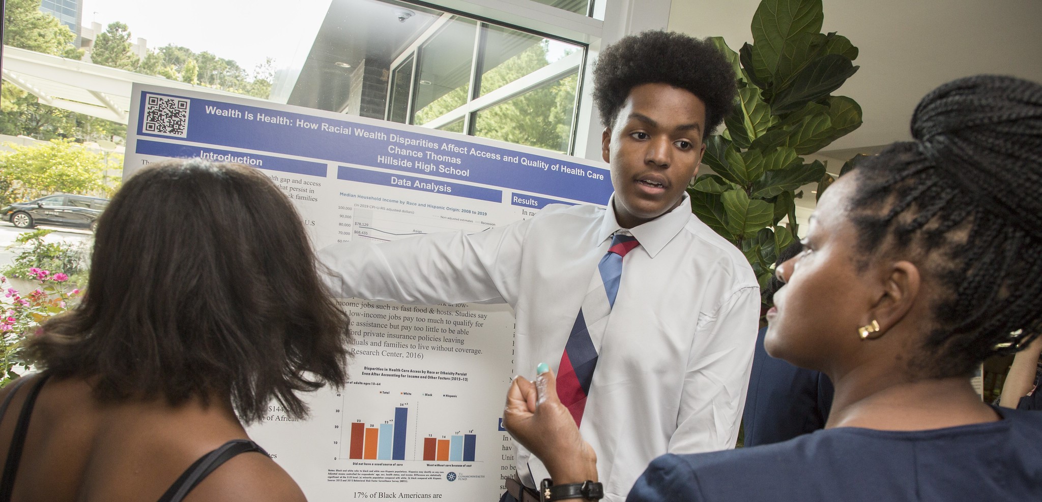 A young student presents his research on a poster board